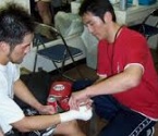 安部光剛 康博の手にテーピングを施す写真